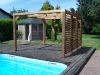Pergola BioClimatique avec vantelles en bois derrière une piscine