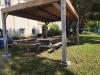 Carport Bioclimatique en Bois avec vantelles au toit  couvrant une table