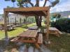Pergola Bioclimatique en Bois avec vantelles au toit  couvrant une table