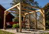 Pergola Bioclimatique en bois avec vantelles sur un côté devant un chalet de jardin